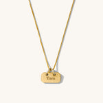 Gold necklace with a tag pendant on a white background