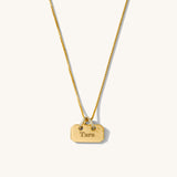 Gold necklace with a tag pendant on a white background