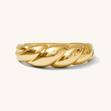 Gold ring with a twisted design on a white background