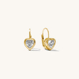 Heart-shaped gold earrings with clear gemstones on a white background