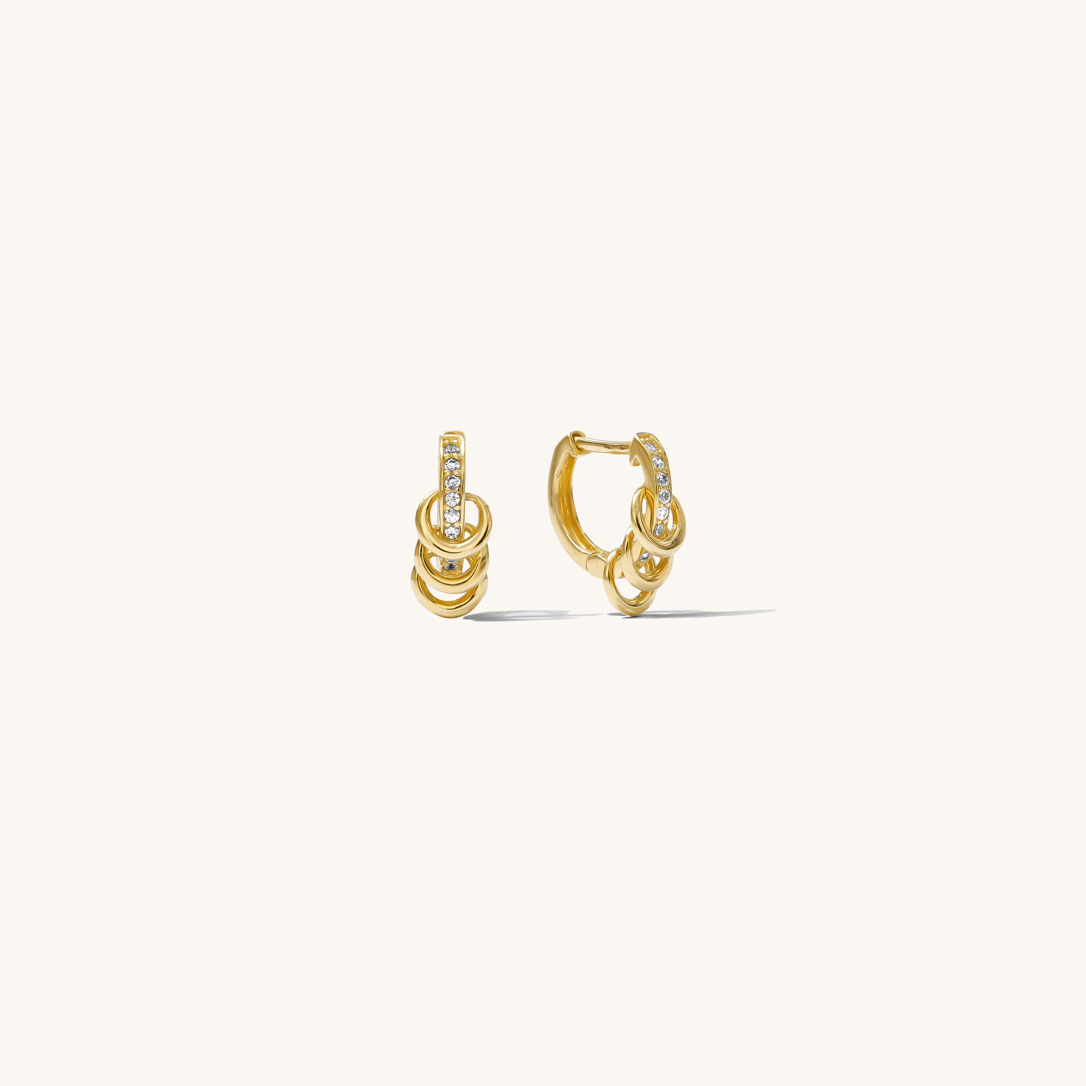 Close up of gold hoops with stones on a white background