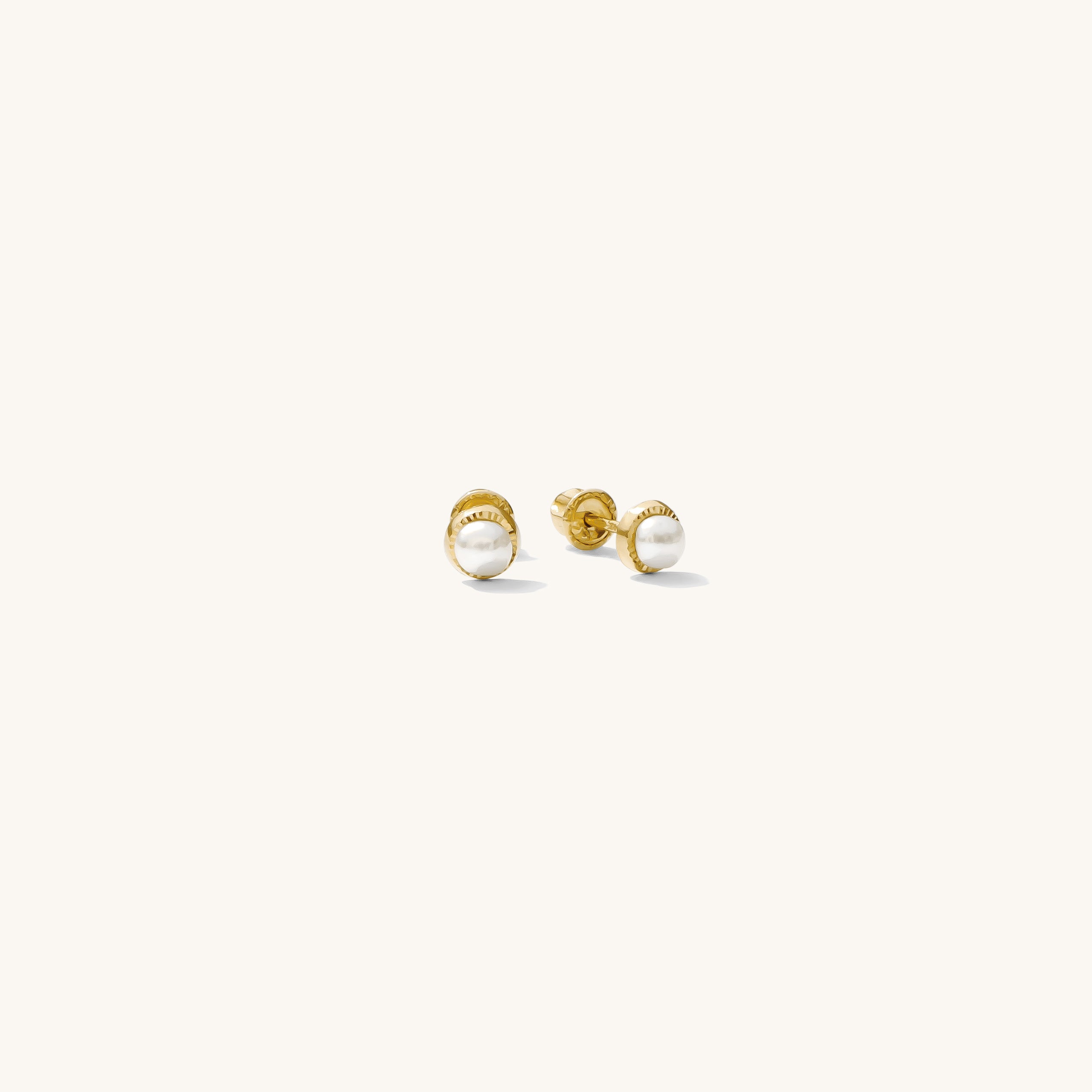 Close up of gold and pearl earrings on a white background 