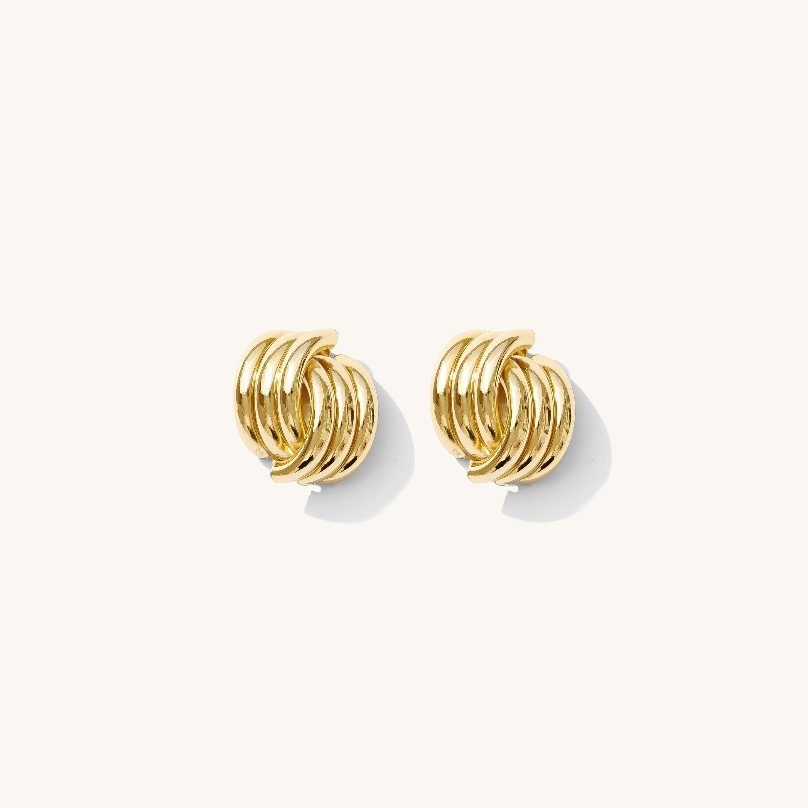 Closeup of gold textured earrings on a white background