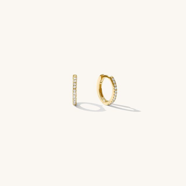 Close up of gold hoops with stones on a white background 