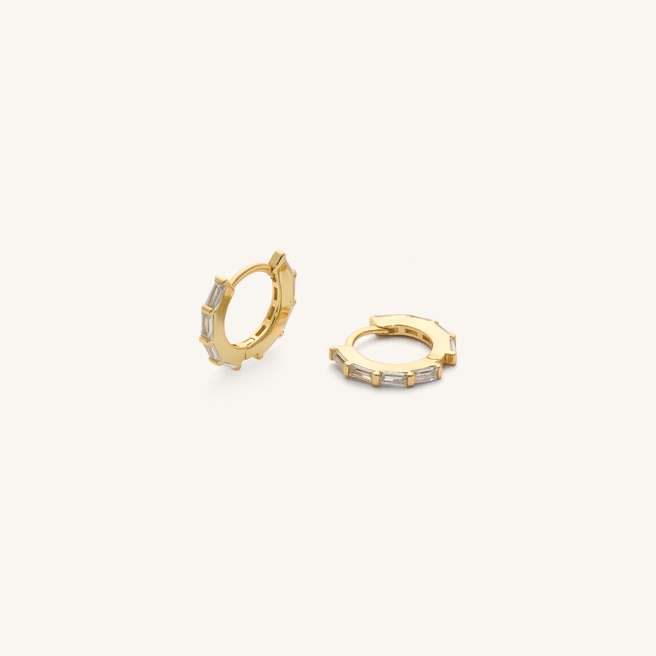 Close up of gold hoops with crystal accents on a white background 