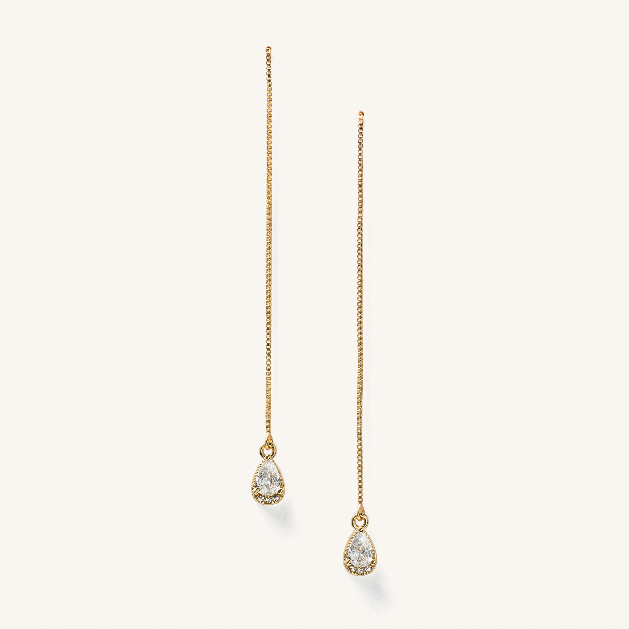 Close up of gold threader earrings on a white background 