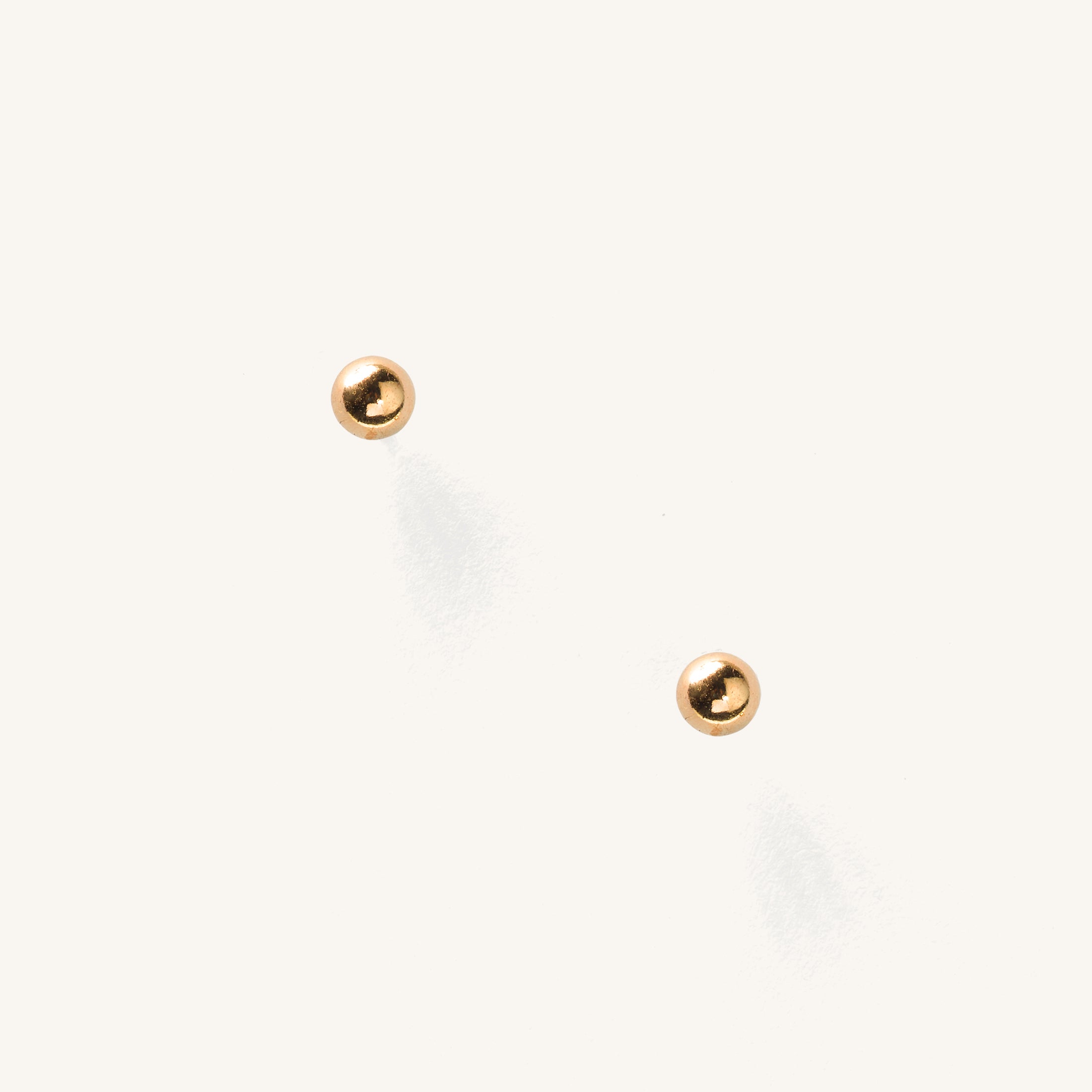 Close up of gold circular studs on a white background 
