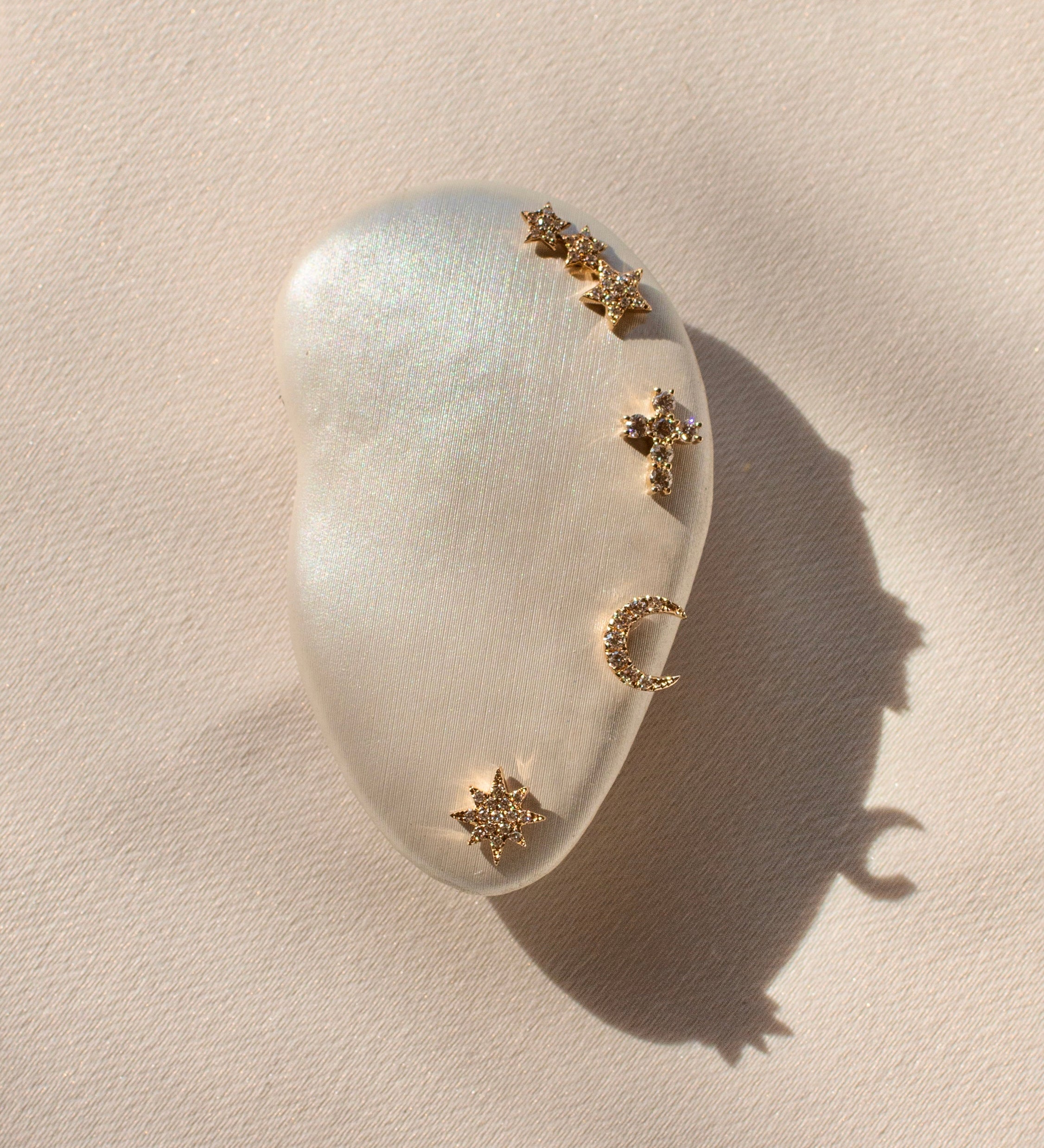 A model ear prop with multiple gold and crystal stud earrings 
